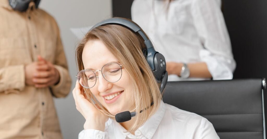 Customer service team working together in a modern call center with headsets and laptops.